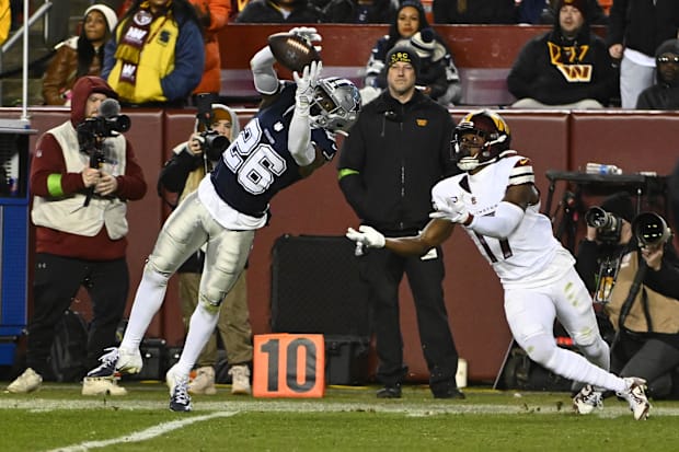 Dallas Cowboys cornerback DaRon Bland intercepts a pass intended for Washington Commanders wide receiver Terry McLaurin.