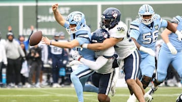 UConn's Pryce Yates, right, combines on the sack of North Carolina quarterback Michael Merdinger during the third annual Wasabi Fenway Bowl at Fenway Park on Saturday, Dec. 28, 2024.