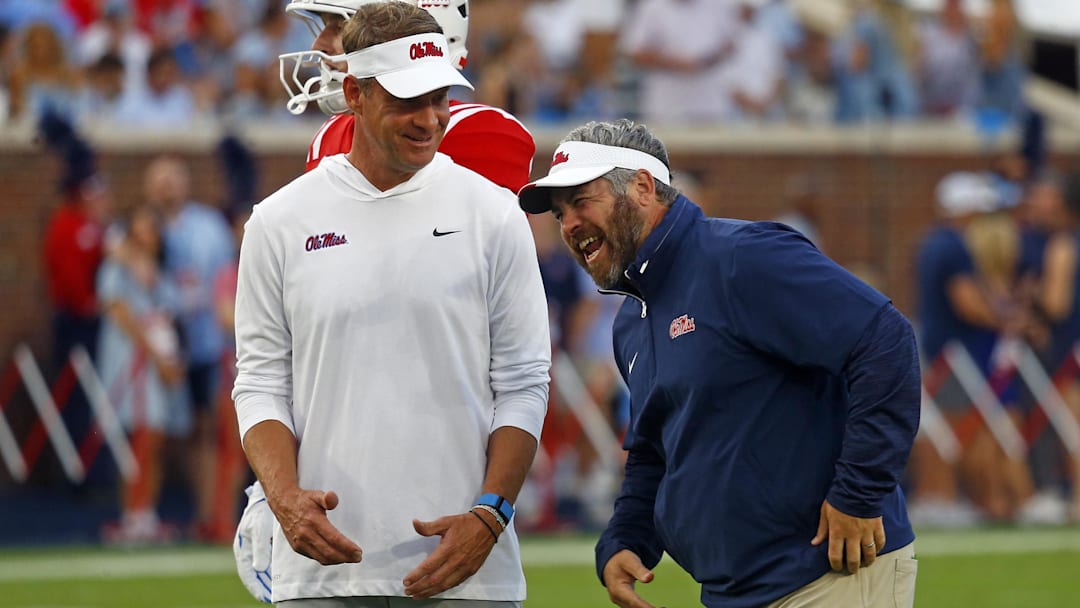 Sep 21, 2024; Oxford, Mississippi, USA; Mississippi Rebels head coach Lane Kiffin (left) shares a laugh with defensive coordinator Pete Golding (right) during warm ups prior to the game against the Georgia Southern Eagles at Vaught-Hemingway Stadium. 