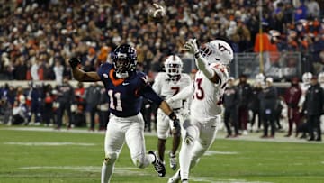 Nov 29, 2025; Charlottesville, Va.; Virginia Tech cornerback Thomas Williams (23) attempts to intercept a pass intended for Virginia wide receiver Trell Harris (11).