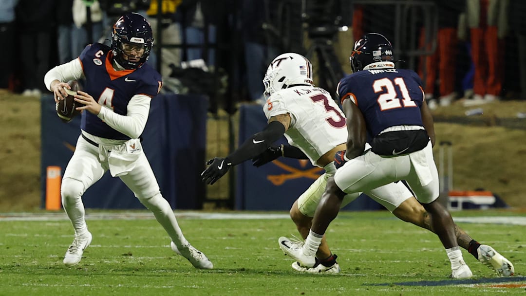 Nov 29, 2025; Charlottesville, Virginia, USA; Virginia Cavaliers quarterback Chandler Morris (4) scrambles from Virginia Tech Hokies linebacker Kaleb Spencer (3) in the second quarter at Scott Stadium. Mandatory Credit: Geoff Burke-Imagn Images