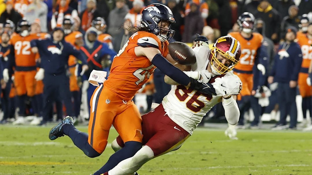 Nov 30, 2025; Landover, Maryland, USA; Denver Broncos linebacker Alex Singleton (49) knocks the ball from Washington Commanders tight end Zach Ertz (86) while attempting a catch in the third quarter at Northwest Stadium. 