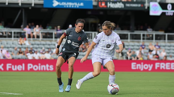 Jun 29, 2024; Louisville, Kentucky, USA;  Racing Louisville FC midfielder Jordan Baggett (right) maneuvers the ball past Bay FC defender Emily Menges (left) during the second half at Lynn Family Stadium. Mandatory Credit: EM Dash-Imagn Images