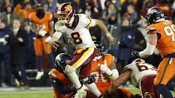 Nov 30, 2025; Landover, Maryland, USA; Washington Commanders quarterback Marcus Mariota (8) runs with the ball as Denver Broncos defensive end John Franklin-Myers (98) and Broncos linebacker Nik Bonitto (15) attempt a tackle during overtime at Northwest Stadium. Mandatory Credit: Geoff Burke-Imagn Images