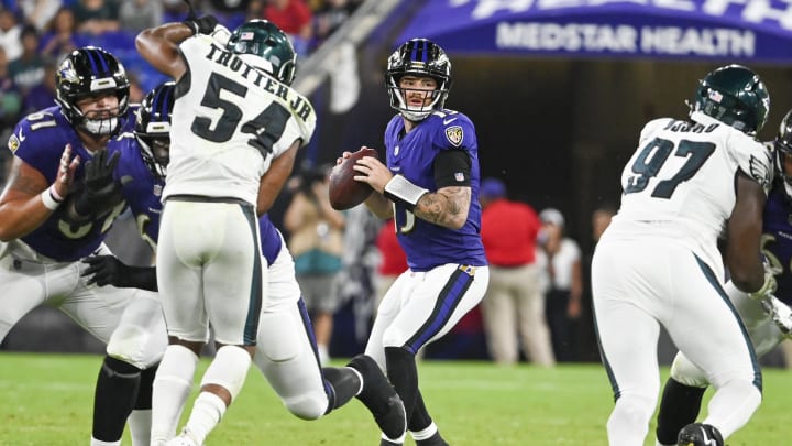 Baltimore Ravens quarterback Devin Leary (13) drops back to pass during the second half of a preseason game against the Philadelphia Eagles with Jeremiah Trotter Jr. (54) closing in.