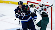 Dec 21, 2024; Winnipeg, Manitoba, CAN;  Winnipeg Jets forward Morgan Barron (36) battles for position with Minnesota Wild forward Marat Khusnutdinov (22) during the third period at Canada Life Centre. Mandatory Credit: Terrence Lee-Imagn Images