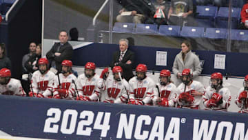 Wisconsin coach Mark Johnson (center) and the Badgers women's hockey team follow the action in their national semifinal against Colgate at Whittemore Center Arena in Durham, N.H., on Friday, March 22, 2024.