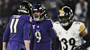 Dec 21, 2024; Baltimore, Maryland, USA;  Baltimore Ravens place kicker Justin Tucker (9) celebrates with punter Jordan Stout (11) after kicking a field goal as Pittsburgh Steelers safety Minkah Fitzpatrick (39) runs by after kicking at M&T Bank Stadium. Mandatory Credit: Tommy Gilligan-Imagn Images
