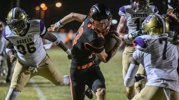 Cocoa QB Brady Hart is driven out of bounds short of the goal line by a trio of Booker defenders i