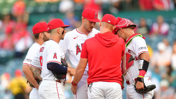 Jul 11, 2024; Anaheim, California, USA; Los Angeles Angels pitching coach Barry Enright (84) meets with pitcher Jack Kochanowicz (64) during the first inning at Angel Stadium. Mandatory Credit: Gary A. Vasquez-USA TODAY Sports