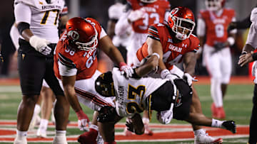 Oct 11, 2025; Salt Lake City, Utah, USA; Arizona State Sun Devils running back Demarius Robinson (23) is thrown down by Utah Utes defensive tackle Dallas Vakalahi (98) and defensive tackle Sione Motuapuaka (44) during the fourth quarter at Rice-Eccles Stadium. Mandatory Credit: Rob Gray-Imagn Images