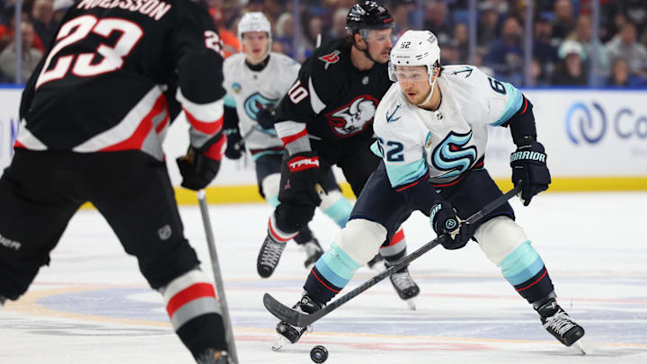 Mar 28, 2026; Buffalo, New York, USA;  Seattle Kraken defenseman Brandon Montour (62) looks to control; the puck as Buffalo Sabres defenseman Mattias Samuelsson (23) defends during the first period at KeyBank Center. Mandatory Credit: Timothy T. Ludwig-Imagn Images