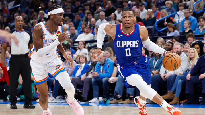 Dec 21, 2023; Oklahoma City, Oklahoma, USA;  LA Clippers guard Russell Westbrook (0) drives around Oklahoma City Thunder guard Shai Gilgeous-Alexander (2) during the second half at Paycom Center. Mandatory Credit: Alonzo Adams-USA TODAY Sports