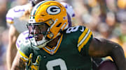 Green Bay Packers running back Josh Jacobs (8) rushes with the football against the Vikings last season.