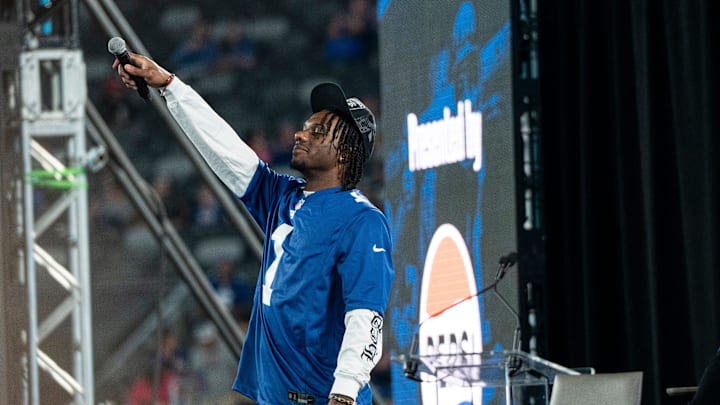 Malik Nabers raises his mic in the air during Giants Fan Fest at MetLife Stadium to celebrate 100 Seasons of the New York Giants, Friday, Sept. 6, 2024.