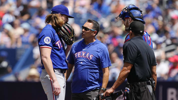 Jul 28, 2024; Toronto, Ontario, CAN; Texas Rangers starting pitcher Jon Gray (22) talks with Rangers staff before throwing a pitch against the Toronto Blue Jays during the first inning at Rogers Centre. Mandatory Credit: John E. Sokolowski-USA TODAY Sports