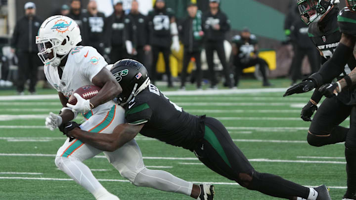 East Rutherford, NJ November 24, 2023 -- Tyreek Hill of Miami is tackled by D.J. Reed of the Jets after making a catch in the first half as the Miami Dolphins defeated the NY Jets 34-13 at MetLife Stadium on November 24, 2023 in East Rutherford, NJ to play in the first Black Friday NFL game.