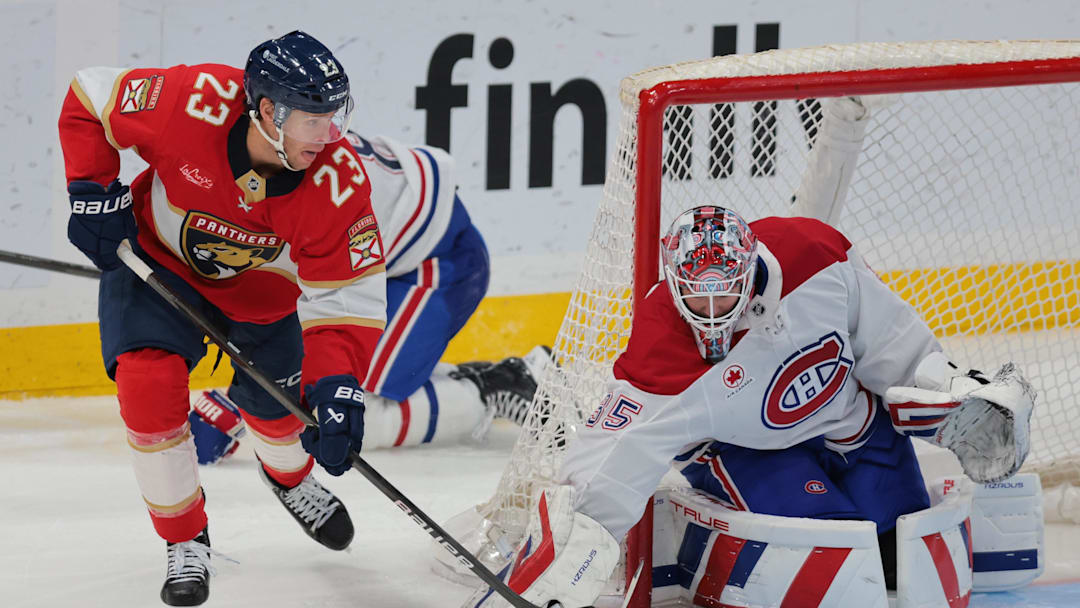 Mar 30, 2025; Sunrise, Florida, USA; Florida Panthers center Carter Verhaeghe (23) moves the puck in front of Montreal Canadiens goaltender Sam Montembeault (35) during the third period at Amerant Bank Arena. Mandatory Credit: Sam Navarro-Imagn Images