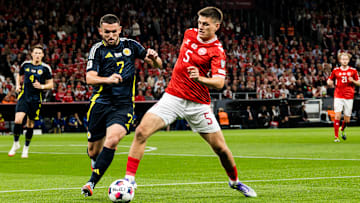 John McGinn #7 of Scotland and Joakim Mæhle #5 of Denmark...