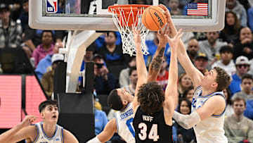 Dec 28, 2024; Inglewood, California, USA; UCLA Bruins guard Kobe Johnson (0), Gonzaga Bulldogs forward Braden Huff (34) and UCLA Bruins forward Tyler Bilodeau (34) reach for a rebound during the first half at Intuit Dome. Mandatory Credit: Robert Hanashiro-Imagn Images