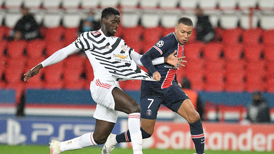 Axel Tuanzebe (left) tangling with Kylian Mbappé.