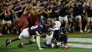 Virginia fans storm the field after their team made a game-winning interception in the end zone on a pass intended for Florida State Seminoles wide receiver Squirrel White (4) in the second overtime at Scott Stadium.