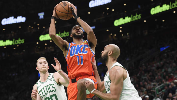 Apr 3, 2024; Boston, Massachusetts, USA; Oklahoma City Thunder guard Isaiah Joe (11) drives to the basket between Boston Celtics forward Sam Hauser (30) and guard Derrick White (9) during the first half at TD Garden. Mandatory Credit: Bob DeChiara-USA TODAY Sports