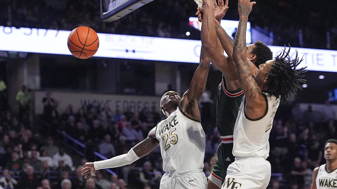 Jan 7, 2026; Winston-Salem, North Carolina, USA; Miami (FL) Hurricanes forward Malik Reneau (5) is surrounded by Wake Forest Demon Deacons forward Tre'von Spillers (25)  and forward Juke Harris (2) during the second half at Lawrence Joel Veterans Memorial Coliseum. Mandatory Credit: Jim Dedmon-Imagn Images