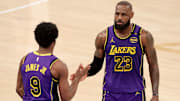 Feb 1, 2025; New York, New York, USA; Los Angeles Lakers guard Bronny James (9) checks in for forward LeBron James (23) during the fourth quarter against the New York Knicks at Madison Square Garden. Mandatory Credit: Brad Penner-Imagn Images