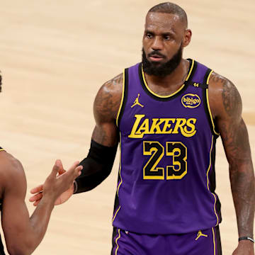 Feb 1, 2025; New York, New York, USA; Los Angeles Lakers guard Bronny James (9) checks in for forward LeBron James (23) during the fourth quarter against the New York Knicks at Madison Square Garden. Mandatory Credit: Brad Penner-Imagn Images