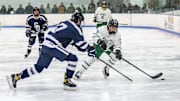 Aidan Cruz (21) of Dartmouth High School moves the puck into the Somerset Berkley end of the ice while Steven Erickson (7) of Somerset Berkley forechecks on the play.