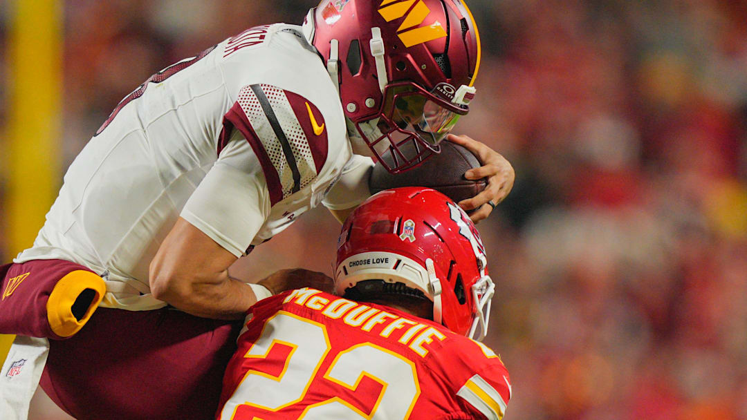 Oct 27, 2025; Kansas City, Missouri, USA; Kansas City Chiefs cornerback Trent McDuffie (22) tackles Washington Commanders quarterback Marcus Mariota (8) during the second quarter of the game at GEHA Field at Arrowhead Stadium. Mandatory Credit: Jay Biggerstaff-Imagn Images