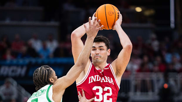 The goalkeeper of the Indiana Hoosiers, Trey Galloway (32), holds the ball while the goalkeeper of the Ducks of Oregon Keeshawn Barthelemy (9)