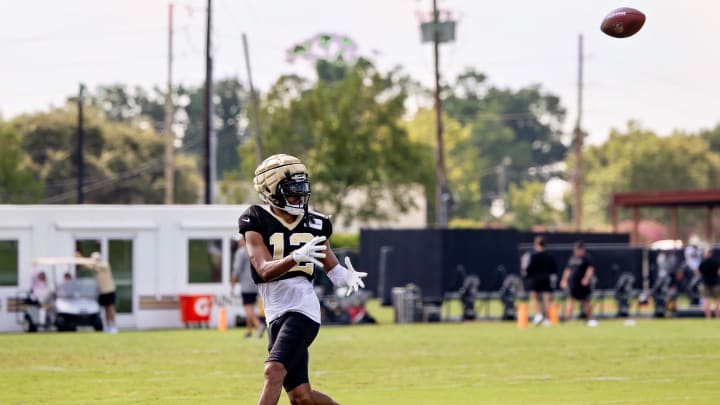 Aug 1, 2023; Metairie, LA, USA;  New Orleans Saints wide receiver Chris Olave (12) catches passes during  training camp at the Ochsner Sports Performance Center. Mandatory Credit: Stephen Lew-USA TODAY Sports