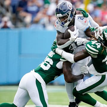 Tennessee Titans running back Tyjae Spears (2) is tackled by New York Jets linebacker Quincy Williams (56) linebacker Jamien Sherwood (44) during the second quarter at Nissan Stadium in Nashville, Tenn., Sunday, Sept. 15, 2024.