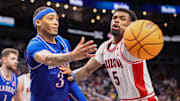 Mar 13, 2025; Kansas City, MO, USA; Kansas Jayhawks guard Dajuan Harris Jr. (3) passes the ball around Arizona Wildcats guard KJ Lewis (5) during the second half at T-Mobile Center. 
