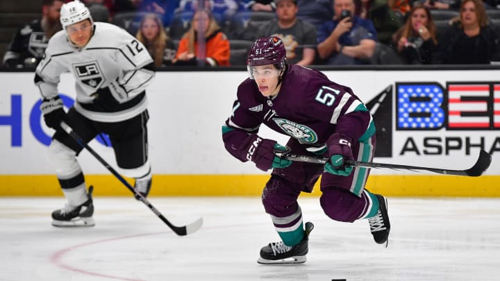 Apr 9, 2024; Anaheim, California, USA; Anaheim Ducks defenseman Olen Zellweger (51) moves the puck ahead of Los Angeles Kings left wing Trevor Moore (12) during the third period at Honda Center. Mandatory Credit: Gary A. Vasquez-USA TODAY Sports