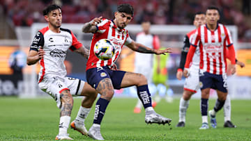 Edgar Zaldívar de Atlas y Víctor Guzmán de Chivas compiten por el esférico en el Play-In