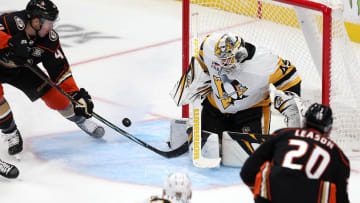 Nov 7, 2023; Anaheim, California, USA; Anaheim Ducks left wing Ross Johnston (44) attempts to shoot a puck against Pittsburgh Penguins goaltender Magnus Hellberg (45) during the third period at Honda Center. Mandatory Credit: Kiyoshi Mio-USA TODAY Sports