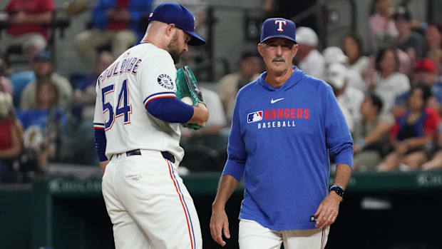 Texas Rangers pitching coach Mike Maddux (31) visits pitcher Danny Coulombe (54) on the mound during the seventh inning again
