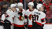 Mar 27, 2025; Detroit, Michigan, USA;  Ottawa Senators center Tim Stützle (18) is congratulated by teammates after scoring in the first period against the Detroit Red Wings at Little Caesars Arena. Mandatory Credit: Rick Osentoski-Imagn Images