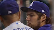 Jul 1, 2021; Washington, District of Columbia, USA; Los Angeles Dodgers starting pitcher Trevor Bauer (R) talks with Dodgers manager Dave Roberts (L) in the dugout against the Washington Nationals in the third inning at Nationals Park.