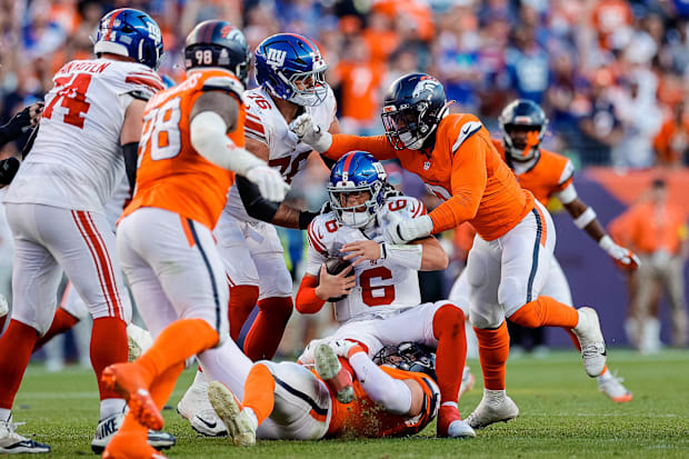 New York Giants quarterback Jaxson Dart (6) is sacked by Broncos defensive end Zach Allen (99) and linebacker Jonathon Cooper