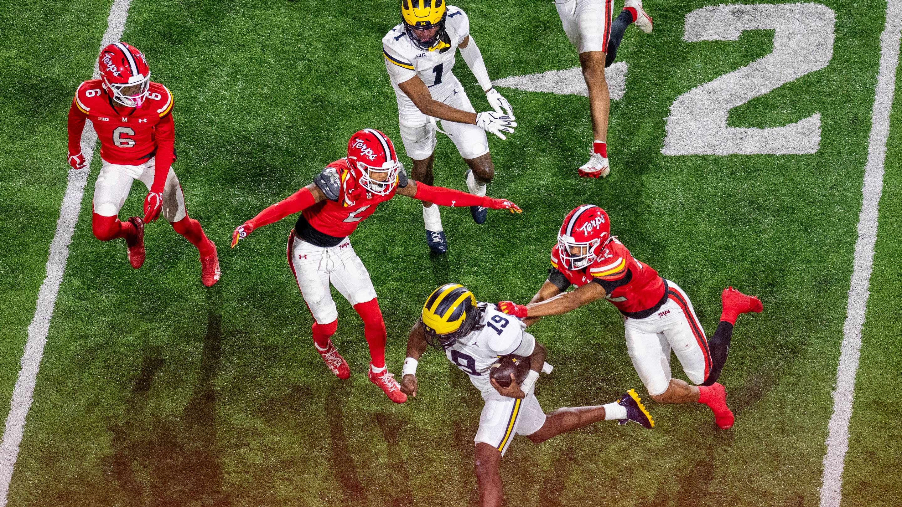 Nov 22, 2025; College Park, Maryland, USA; Michigan Wolverines quarterback Bryce Underwood (19) rushes towards the sidelines as Maryland Terrapins defensive back Jalen Huskey (22) defends during the second half at SECU Stadium. Mandatory Credit: Tommy Gilligan-Imagn Images