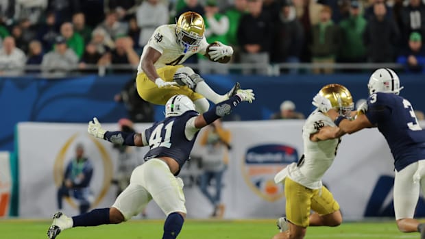 Notre Dame running back Jeremiyah Love hurdles a defender against Penn State in 2025 Orange Bow