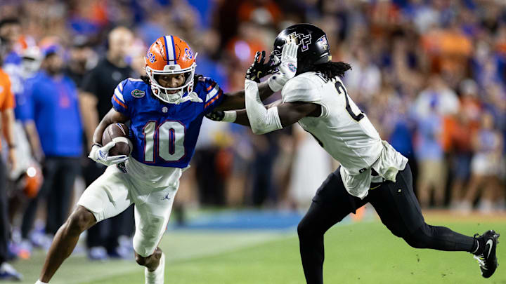 Oct 5, 2024; Gainesville, Florida, USA; Florida Gators wide receiver Tank Hawkins (10) stiff arms UCF Knights defensive back Mac McWilliams (20) during the second half at Ben Hill Griffin Stadium. Mandatory Credit: Matt Pendleton-Imagn Images
