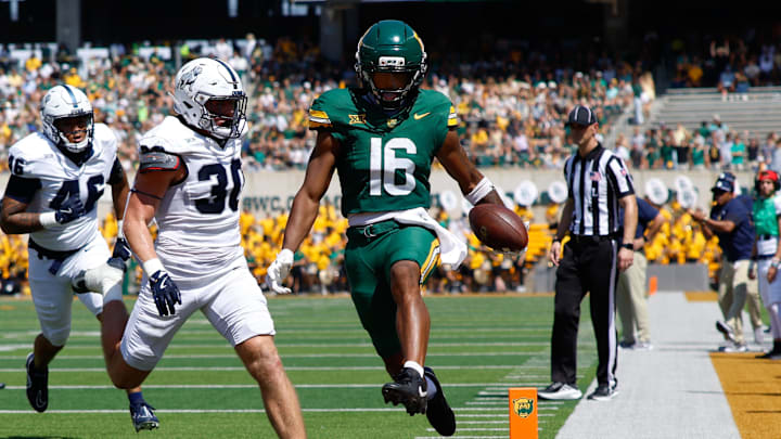 Sep 13, 2025; Waco, Texas, USA; Baylor Bears wide receiver Kobe Prentice (16) scores a touchdown against Samford Bulldogs linebacker Carson Sloan (30) during the first half at McLane Stadium. Mandatory Credit: Chris Jones-Imagn Images