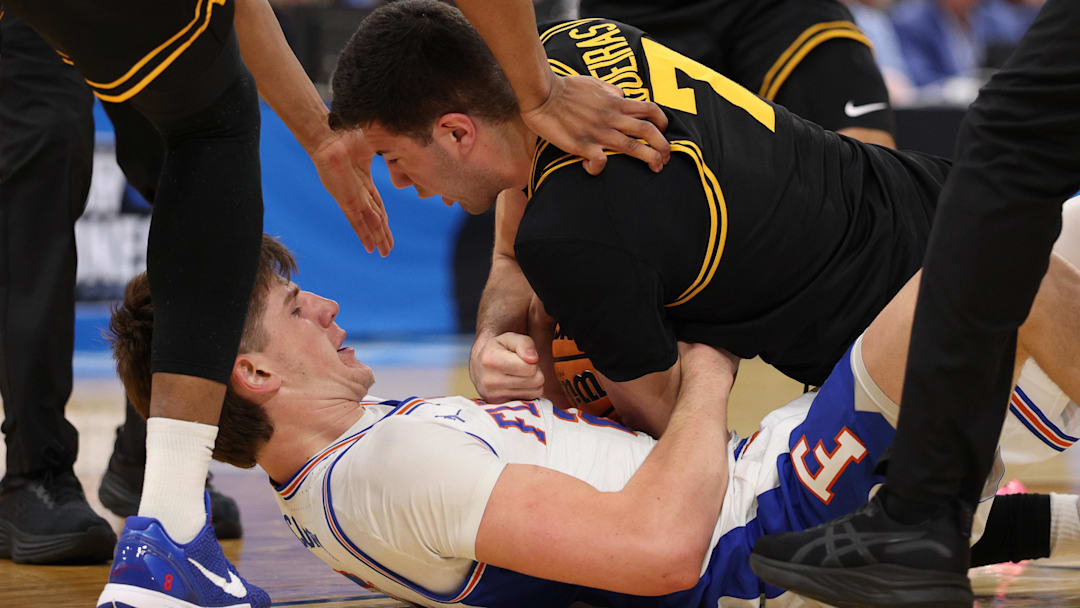 Florida Gators forward Alex Condon (21) and Iowa Hawkeyes forward Alvaro Folgueiras (7) force a jump ball in the first half.