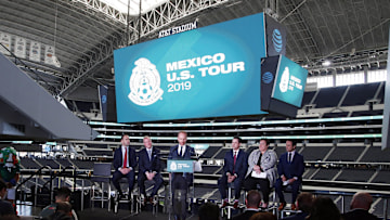 Nov 28, 2018; Arlington, TX, USA; President federacion Mexicana de futbol Gilberto Hernandez speaks to the media as (L to R) Soccer United Marketing senior vice president Camilo Durana and Dallas Cowboys vice president Jerry Jones Jr. and FC Dallas chief operating officer Jimmy Smith and Dallas Sports Commission executive director Monica Paul and Univision personality Alejandro Berry look on during the press conference at AT&T Stadium.