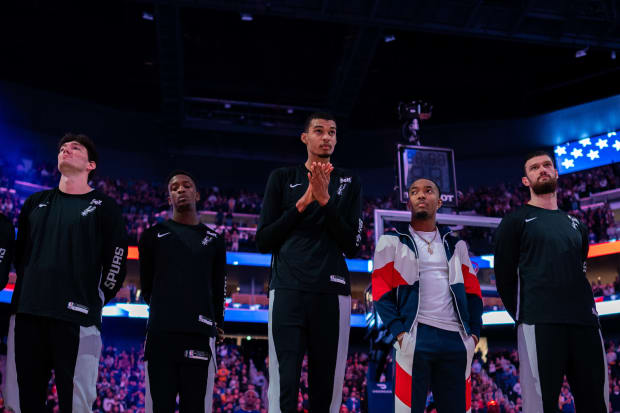 San Antonio Spurs center Victor Wembanyama (1, center) stands with his teammates during the national anthem at Chase Center.